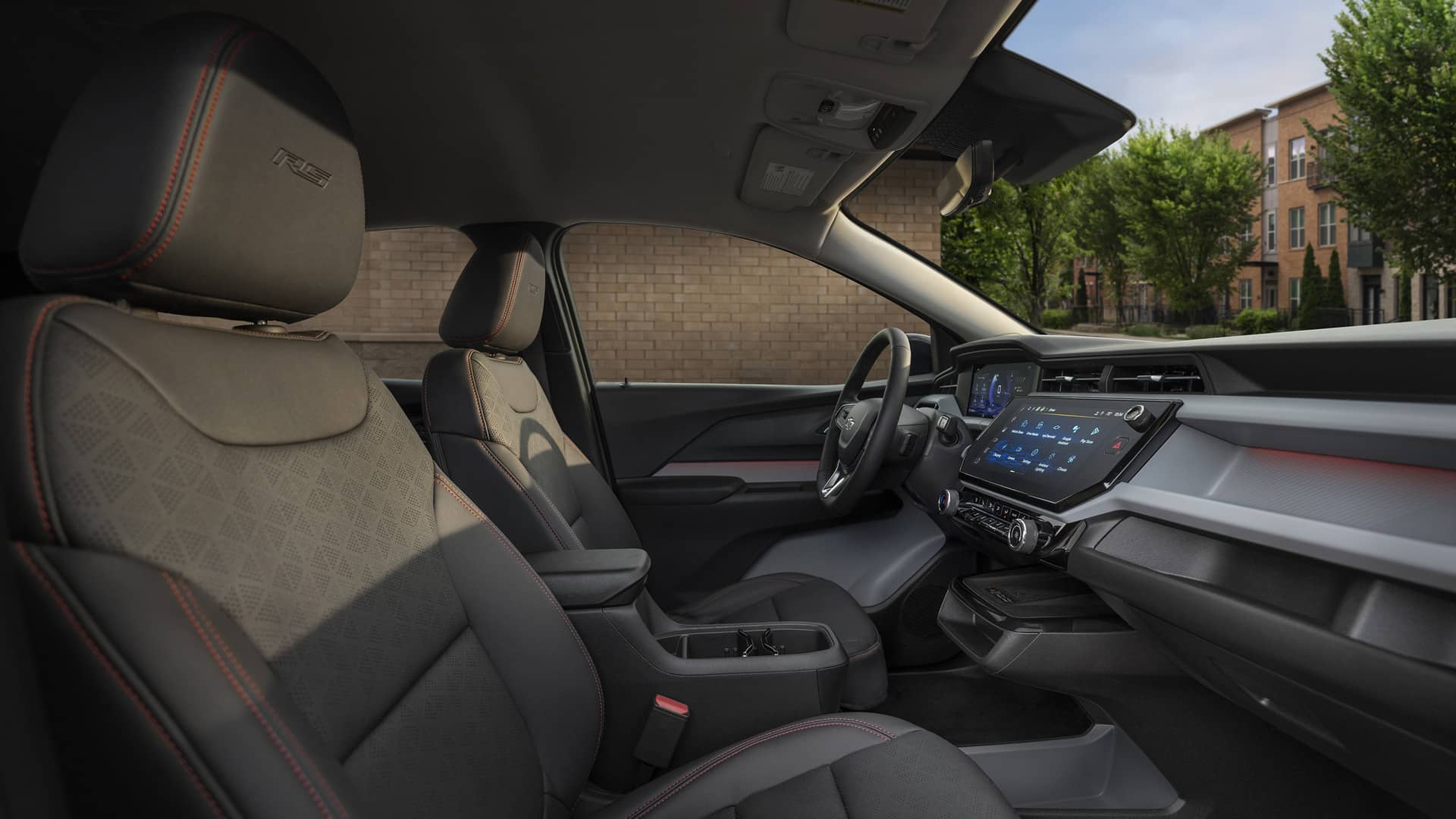 Modern car interior with sleek dashboard, digital display, and contoured seating with red stitching.