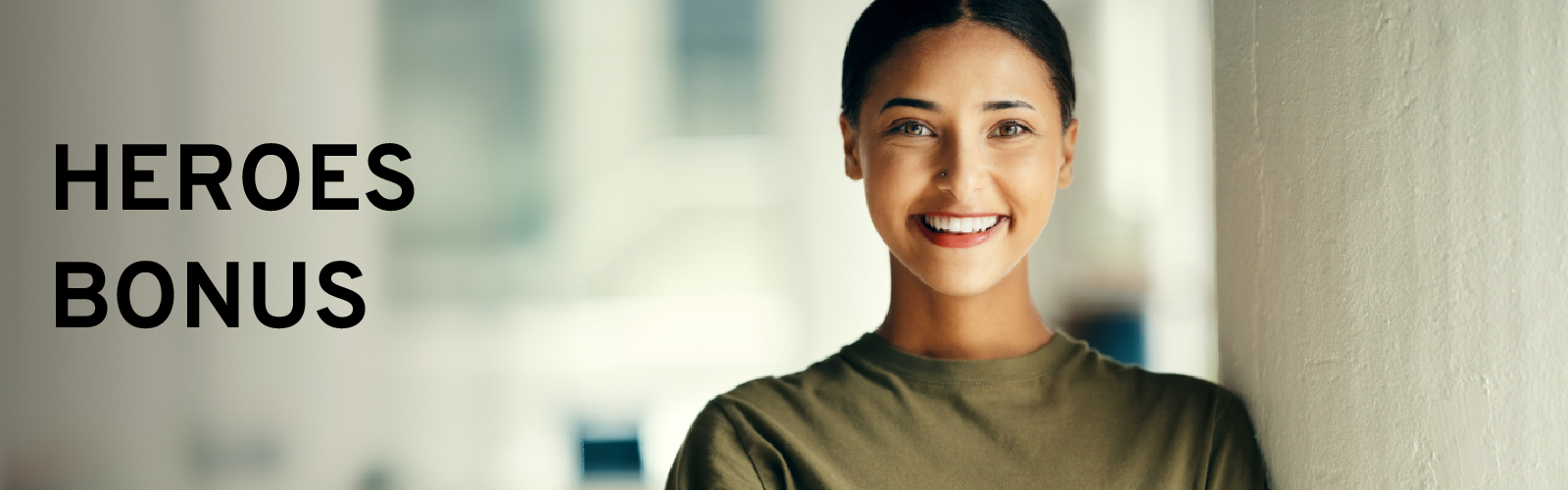 Smiling person in casual attire next to "Heroes Bonus" text, suggesting a positive offer.