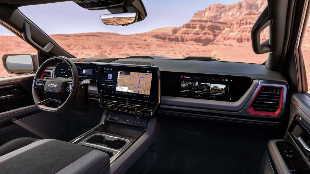 Modern car dashboard featuring a touchscreen navigation system and digital displays with a desert view.